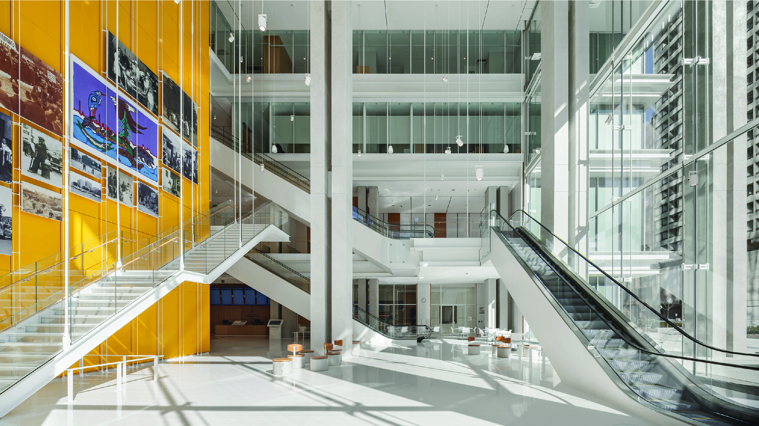 Atrium interior servicing high traffic public floors with yellow quartz clad elevator core and feature images