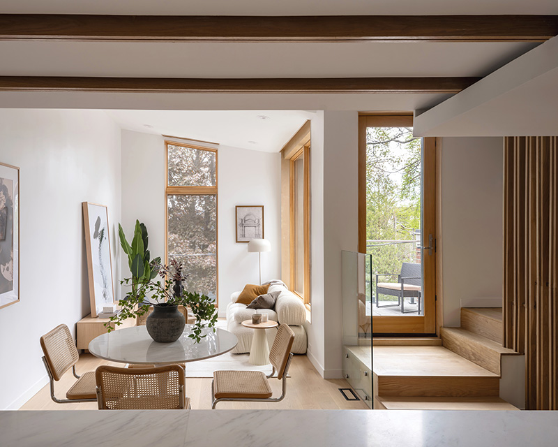 A white sunlit interior of a living room with wood accents