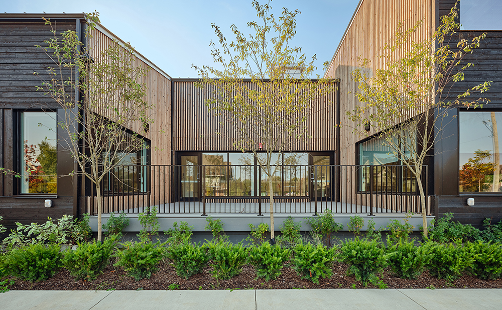 An exterior courtyard surrounded by walls finished with vertical strip siding