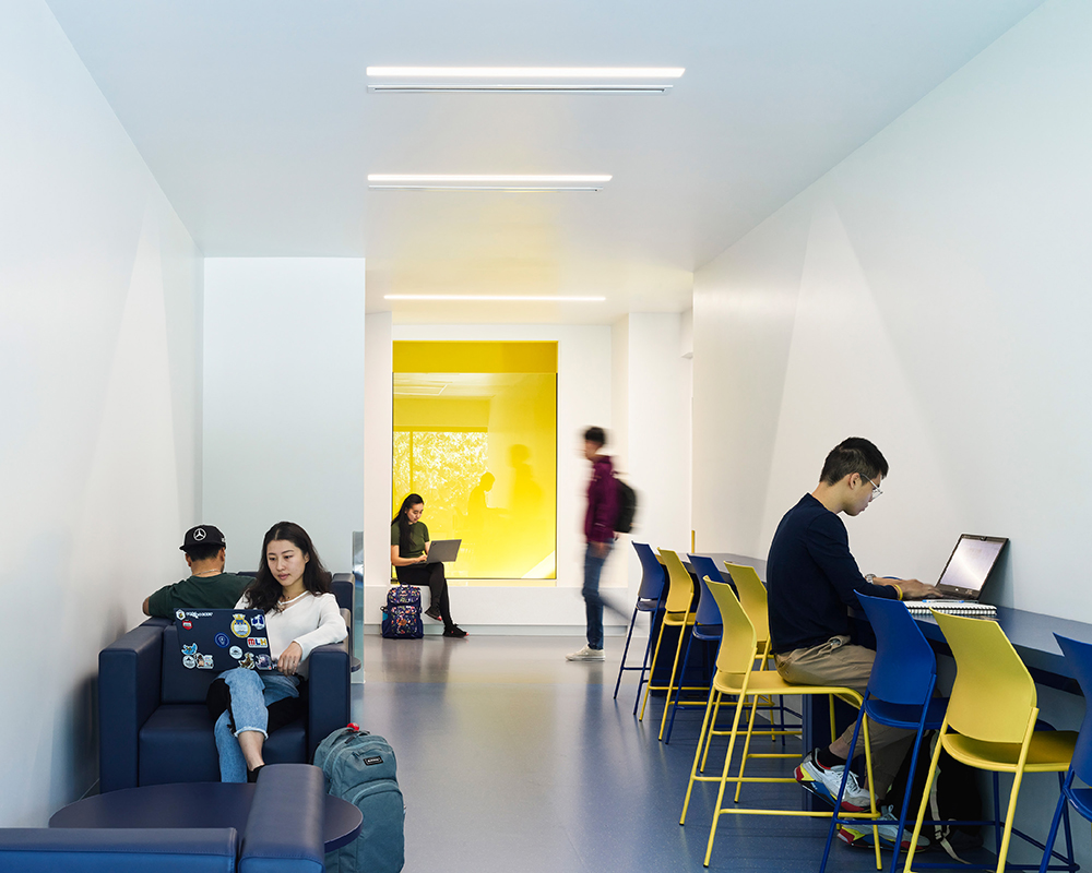 A bright interior workspace with a yellow accent wall