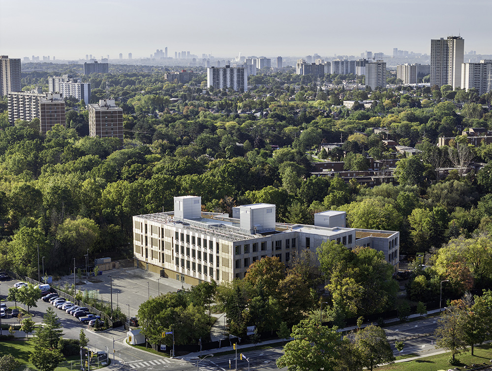 An aerial view of a midrise office building surrounded by trees