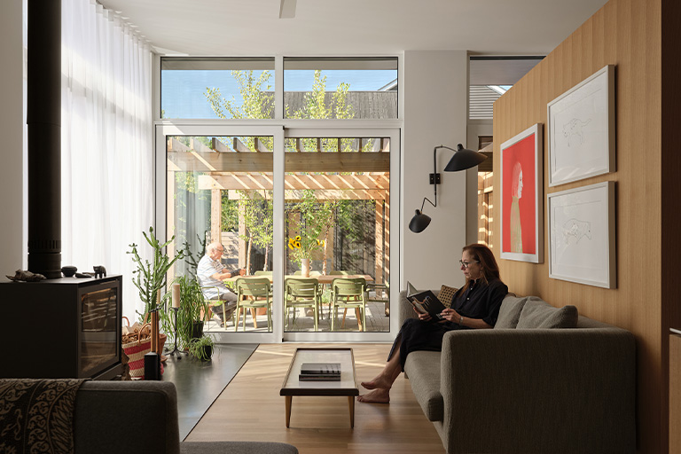 A bright living room with large glass doors opening to a sunlit patio