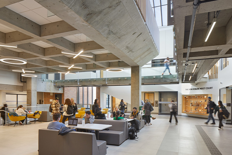 A spacious interior of an academic building with exposed concrete structure