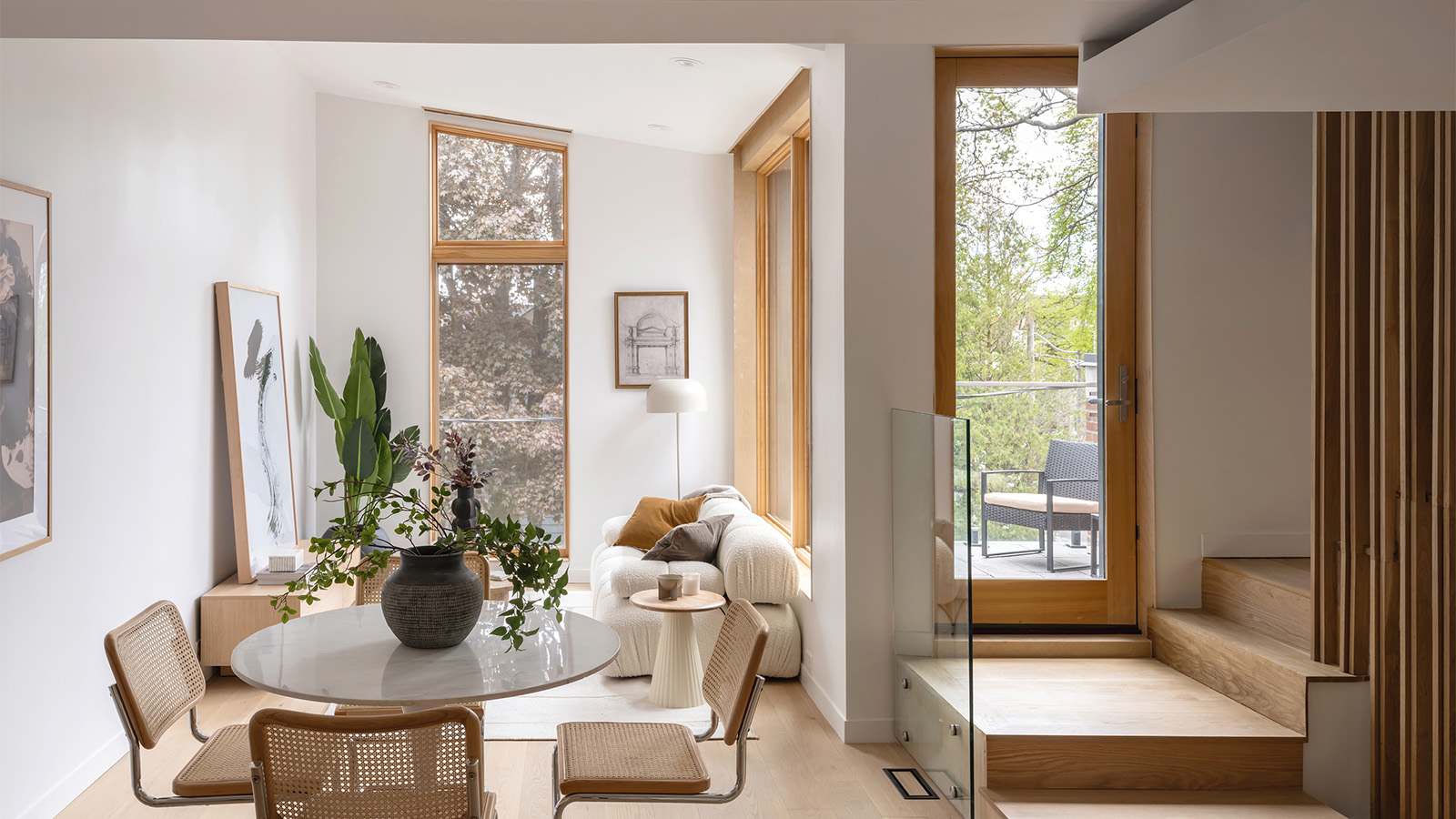 A white sunlit interior of a living room with wood accents