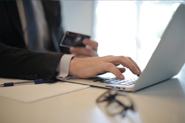 Individual typing on a laptop