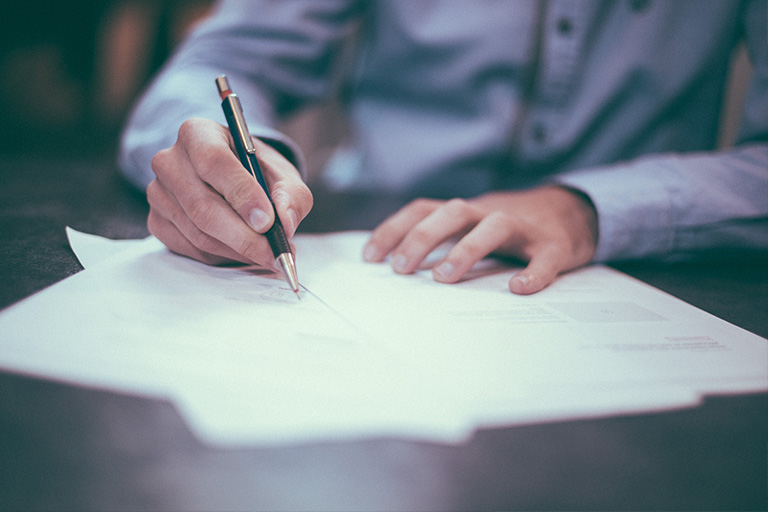 image of person writing on a piece of paper