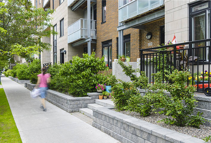 Person walks by a set of townhomes. 