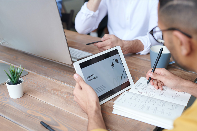 Image of two individuals working at a table