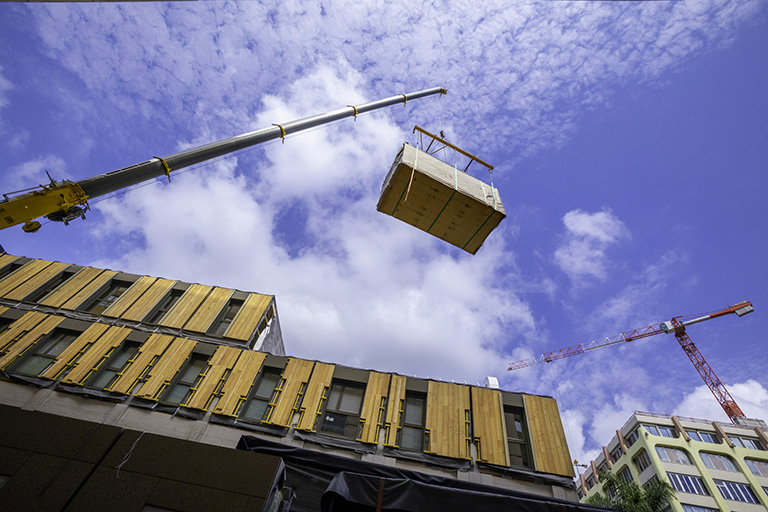 A Construction site with crane lifting a large parcel