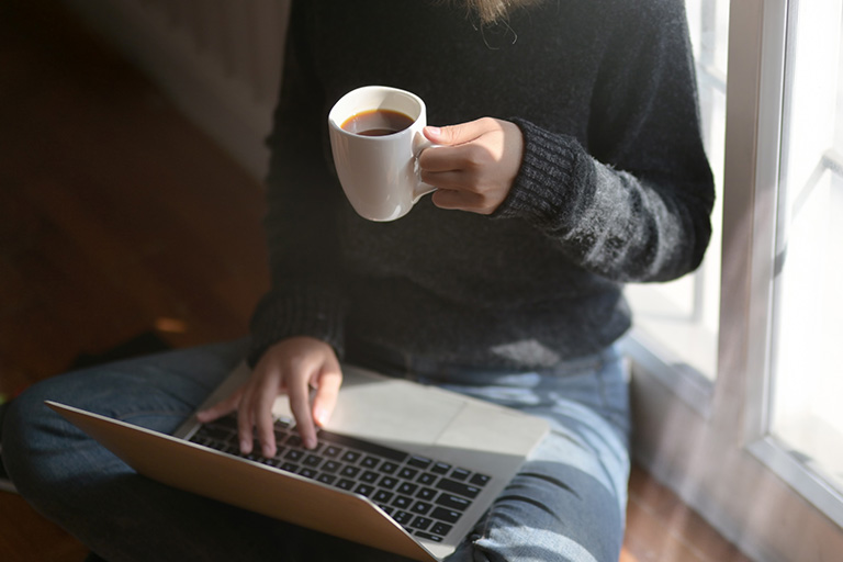 person with a computer and coffeee