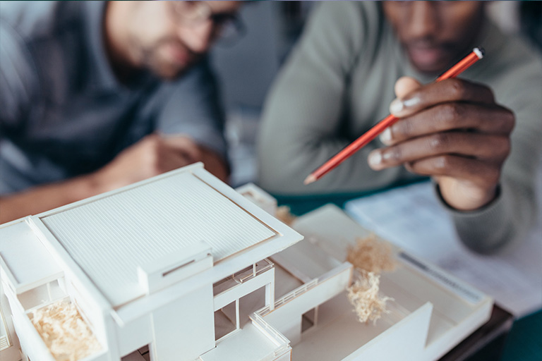 two men looking at an architectural model