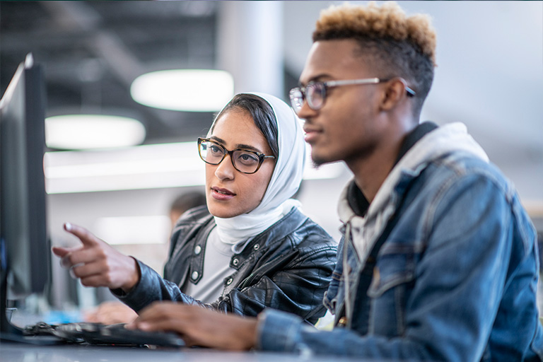 Two students working in front of a computer