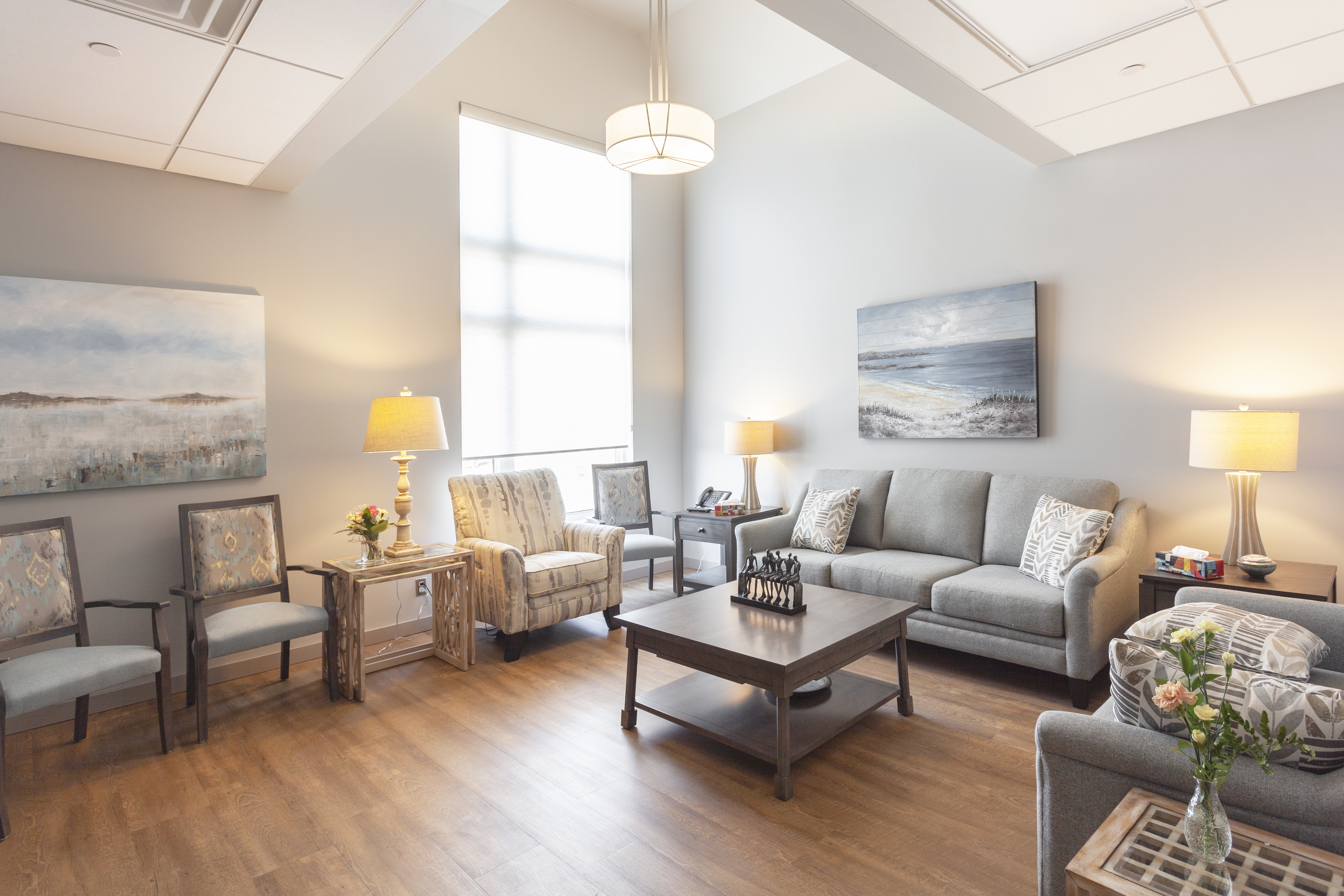 Warm, living-room space with domestic furnishings and a large window.