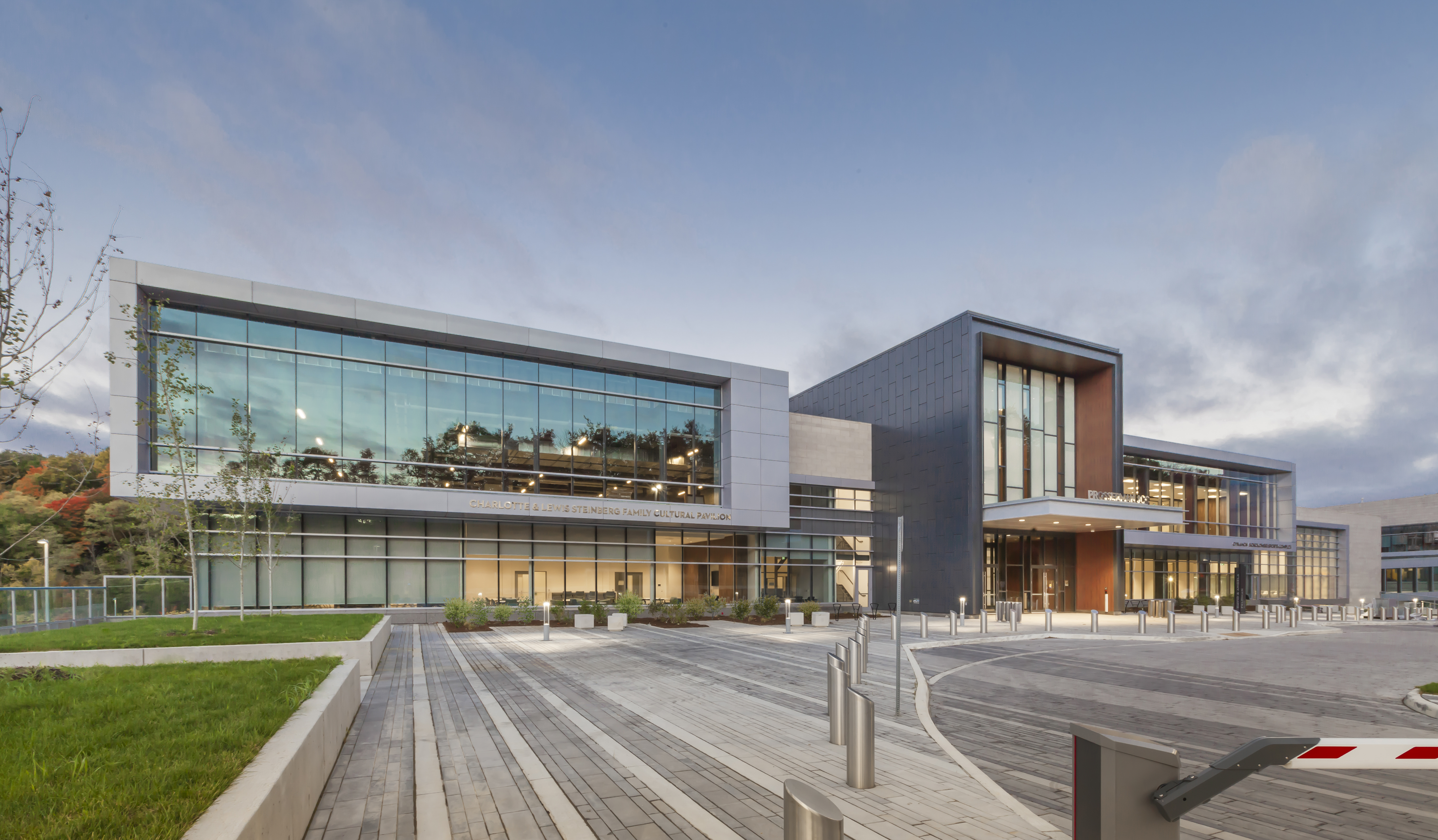 Large, glass and metal building made up of three intersecting rectangular volumes. On the left, a wide, squat silver volume faced with glass; in the middle, a tall narrow black volume with a projecting canopy over the main entrance; on the right, another wide silver volume faced with glass.